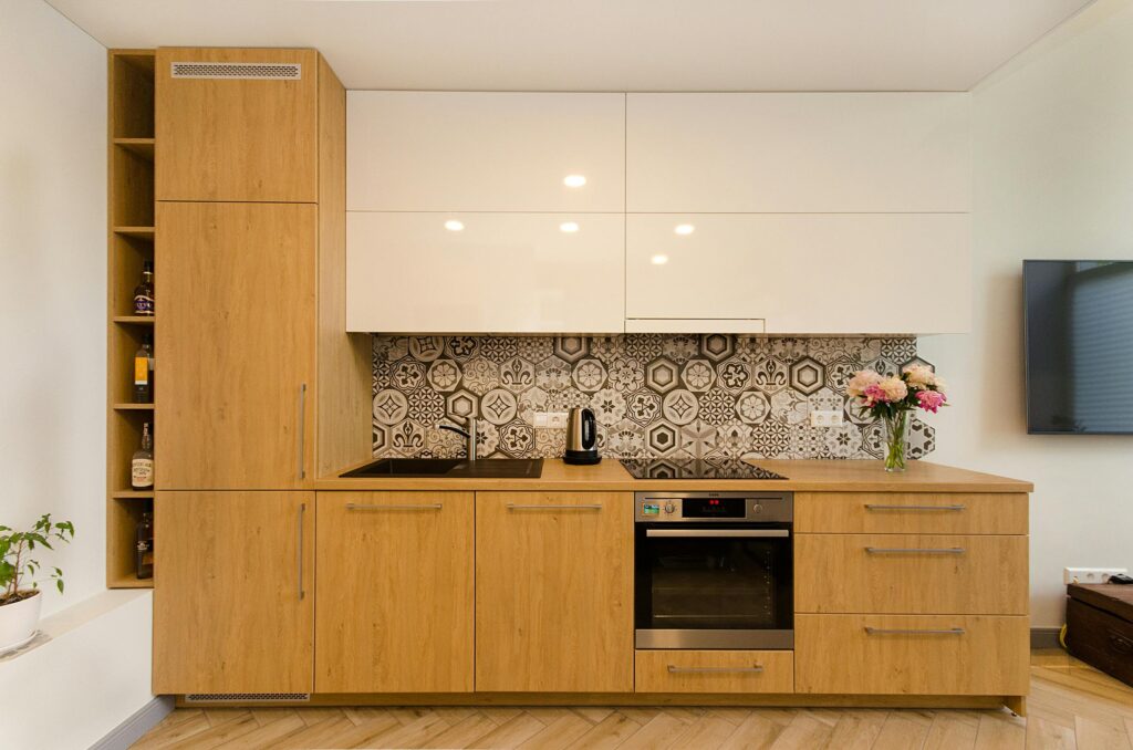 Contemporary kitchen with wooden cabinets and geometric tile backsplash.
